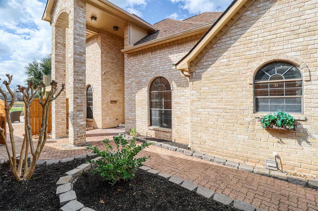 Gated soaring 2-story side entrance allows for privacy and security and features a paved walkway into backyard ideal for entertaining family and friends.