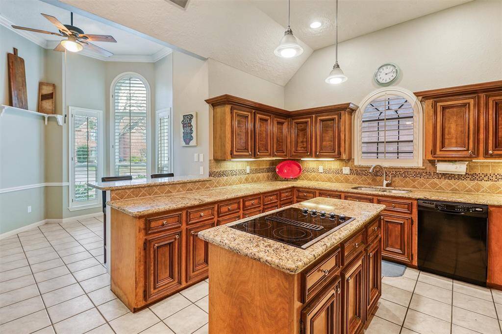 Large island kitchen offers high ceilings, lots of cabinets for storage, and lots of granite counter space for cooking and presenting your favorite food for entertaining family and friends.