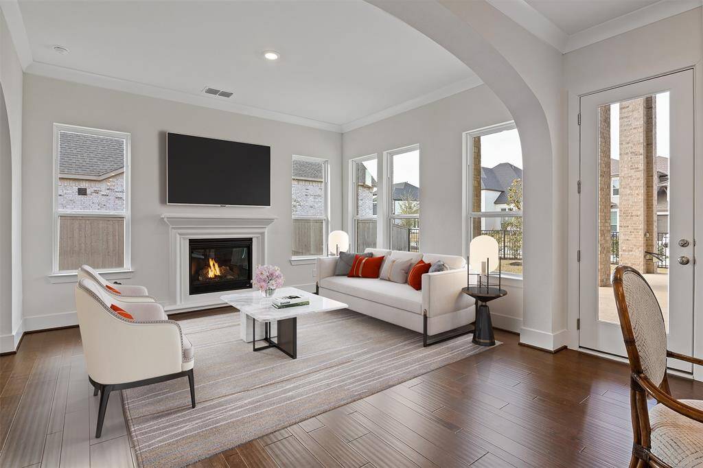 Experience this inviting, virtually staged family room, featuring a cozy fireplace and abundant natural light. Perfect for relaxation and gatherings.
