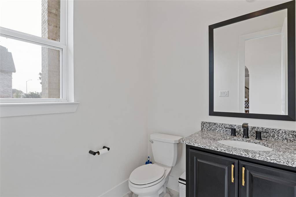 Stylish downstairs half bath with modern fixtures and ample natural light.