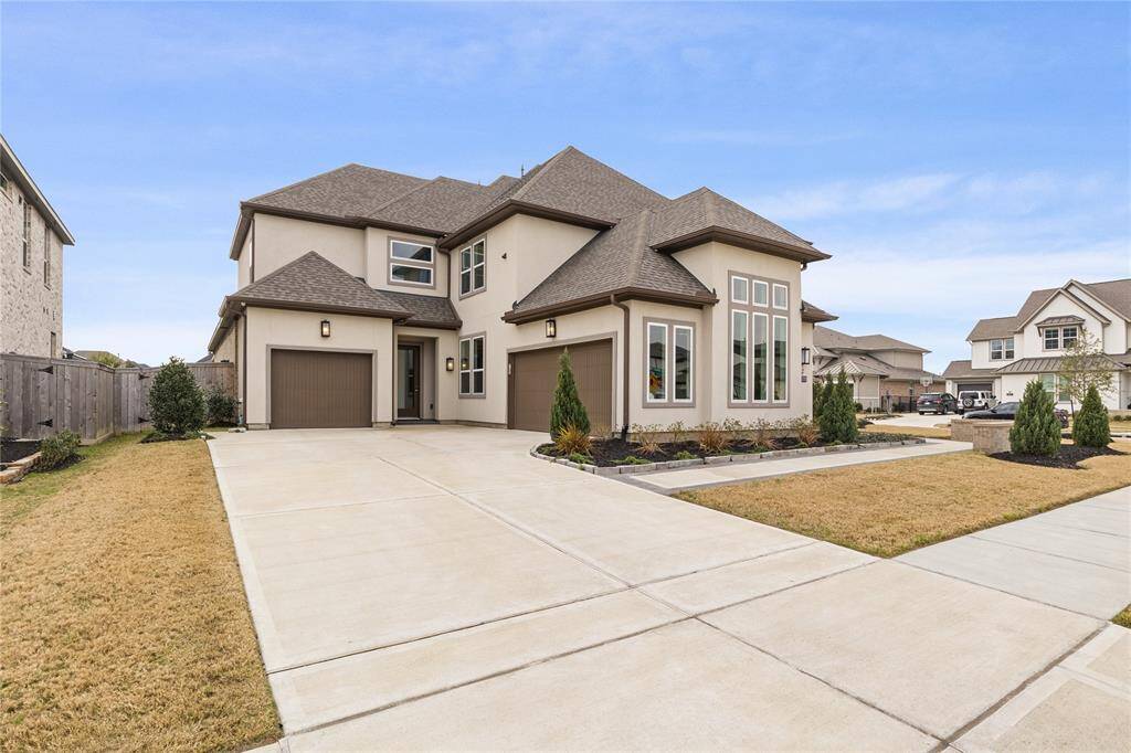 This spacious two-story home features a modern design with a large driveway and attached garages. Situated in a quiet neighborhood, it offers a welcoming and upscale curb appeal.
