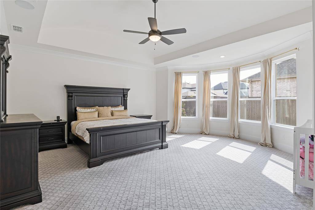 Spacious and inviting primary bedroom with abundant natural light and elegant finishes.