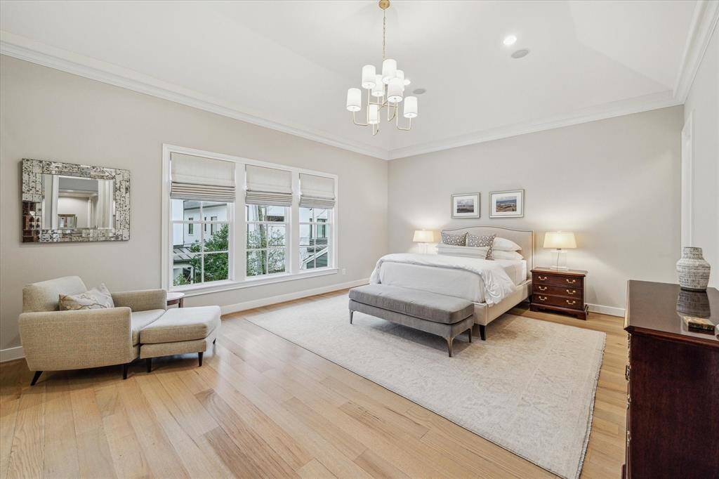 PRIMARY BEDROOM.  A serene haven away from the hustle and bustle of daily life featuring a gentle cream and white color palette, new Serena and Lily chandelier and woven Roman shades.
