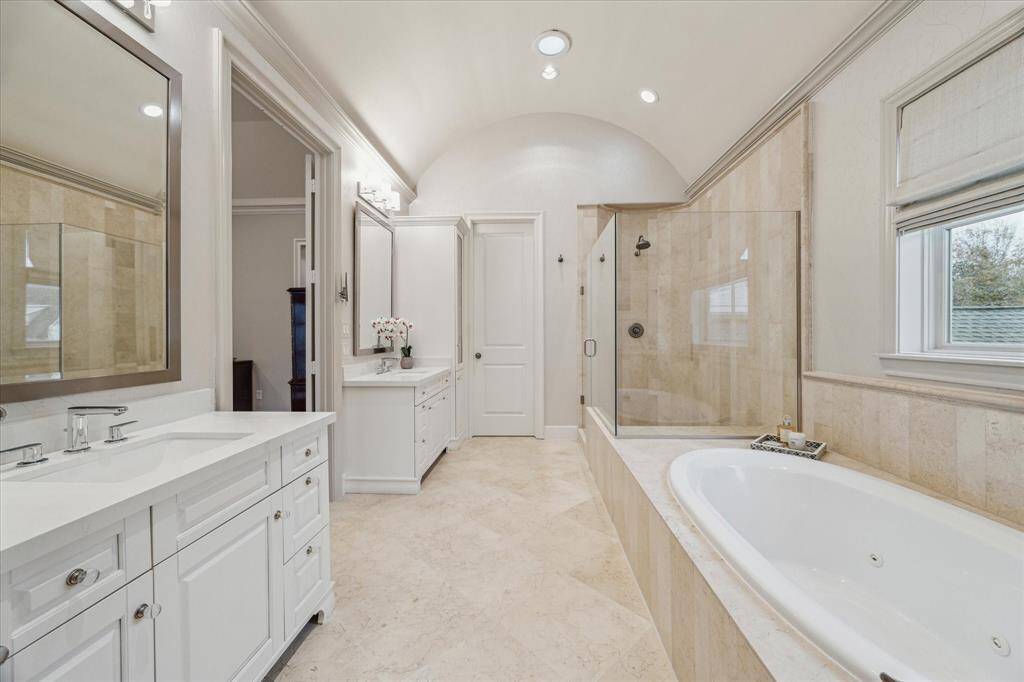 PRIMARY BATHROOM.  Updated in keeping with the rest of the home with a pleasing combination of creams and whites.  New quartz countertops installed, new light fixtures, faucet, toilet and hardware.
