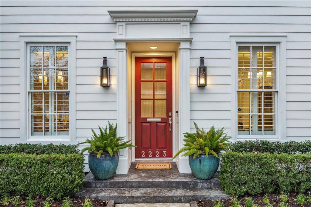 Welcoming front porch with coach lanterns and slate tile flooring.