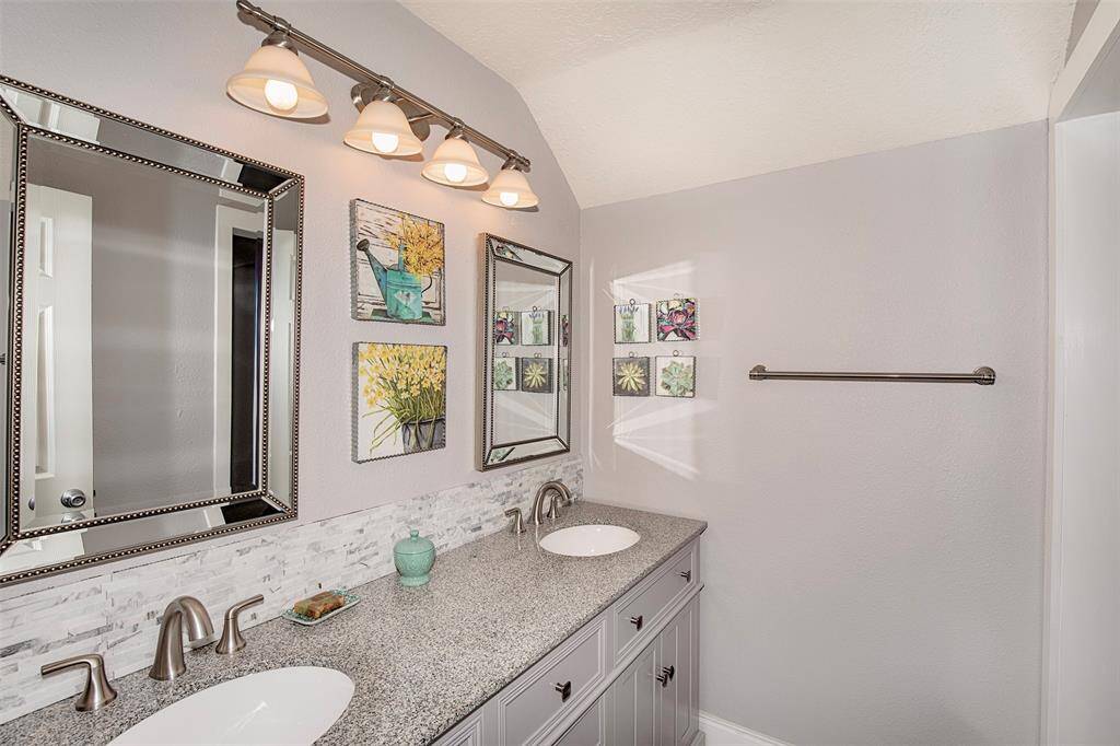 This photo showcases a welcoming foyer with high ceilings, featuring a modern light fixture and wood flooring. The staircase with a sleek railing leads upstairs, and there's a large window near the door for natural light.