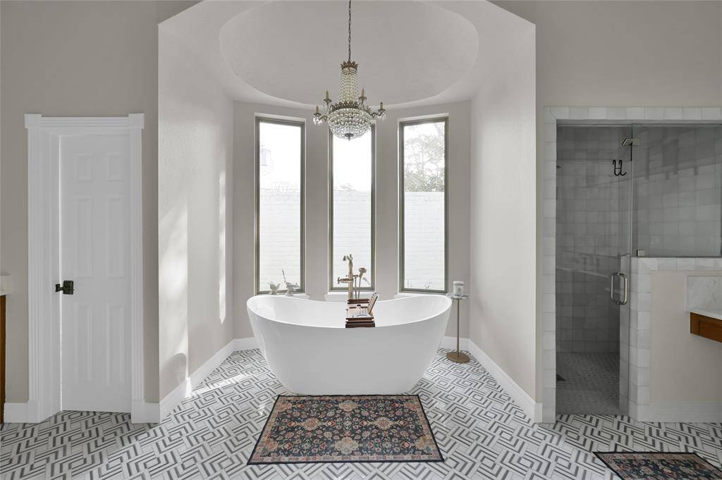Walking into the primary bathroom is a stunning experience. Chandelier, soaking tub, shower, separate vanities, and his and her closets are just the start of the space.