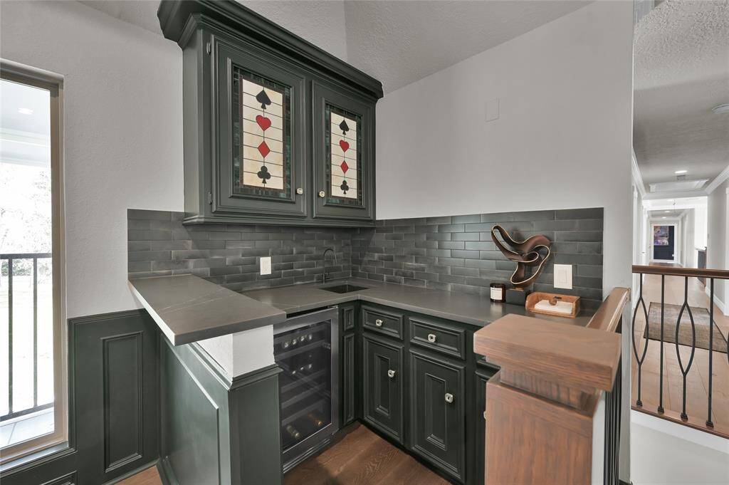 Another view of the wet bar with built in beverage fridge and tons of storage.