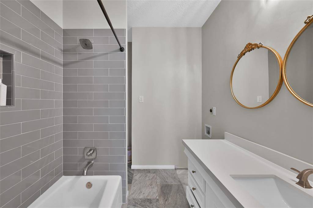 The guest house bathroom has an updated shower/tub combination, laundry connections, and tons of storage.