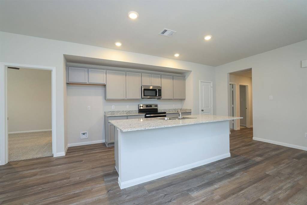 The light gray cabinetry paired with the granite counter tops creates a stylish Kitchen.