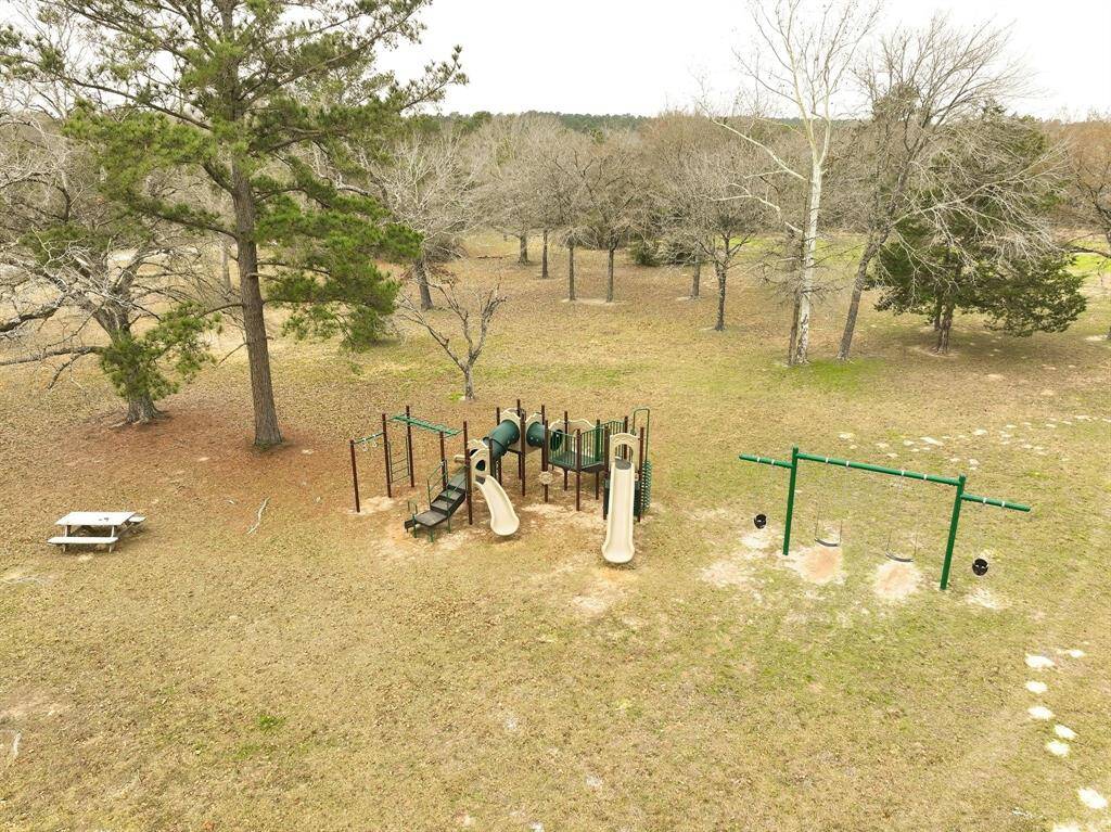 Littles can get their fill of fun in the park area with a playground featuring slides and swings, surrounded by mature trees. There's also a picnic table, providing a great spot for family activities and outdoor recreation.