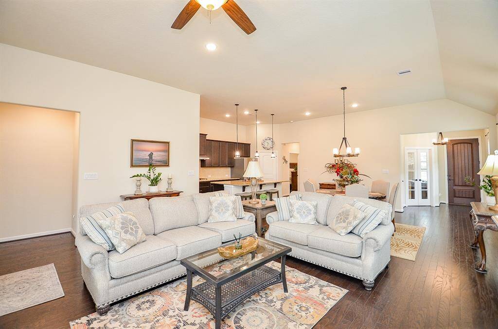 The family room is the heart of the home, seamlessly blending comfort and sophistication. Gleaming wood floors extend throughout, complemented by a high ceiling with a stylish fan and recessed lighting, creating an inviting and well-lit space for relaxation or gatherings.