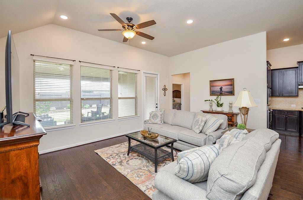 With its soaring ceilings and a wall of oversized windows, natural light floods the space, creating a warm and inviting atmosphere. The views extend to the covered patio and meticulously landscaped backyard, making it an ideal spot for entertaining or simply relaxing in style.