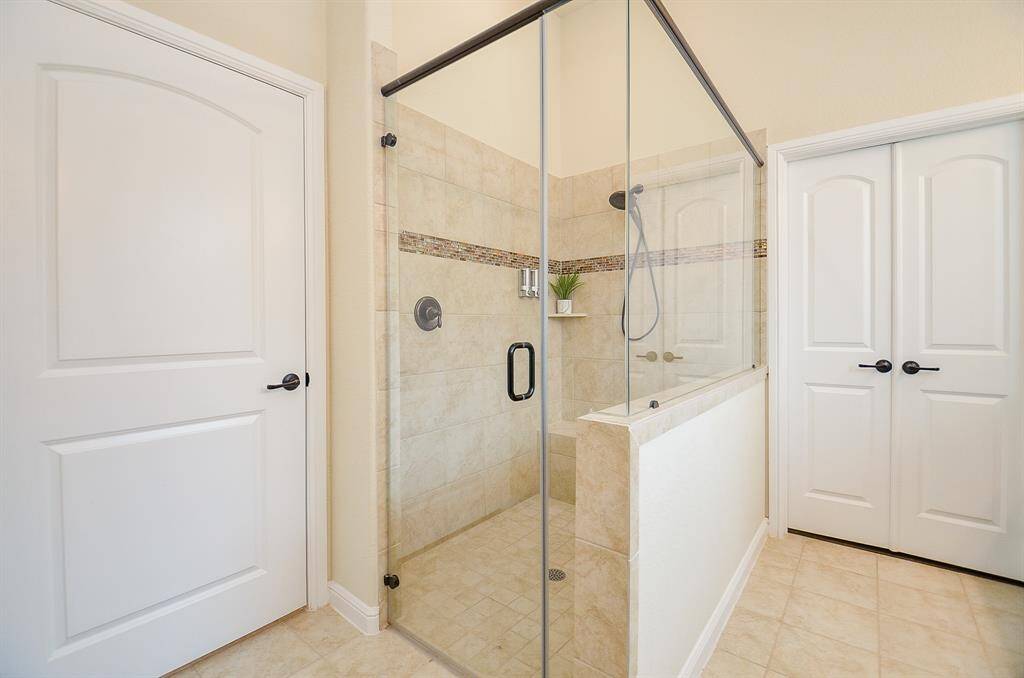 To complete the space, a spacious frameless glass walk-in shower with a generous bench offers both style and functionality, creating a perfect spot to unwind.