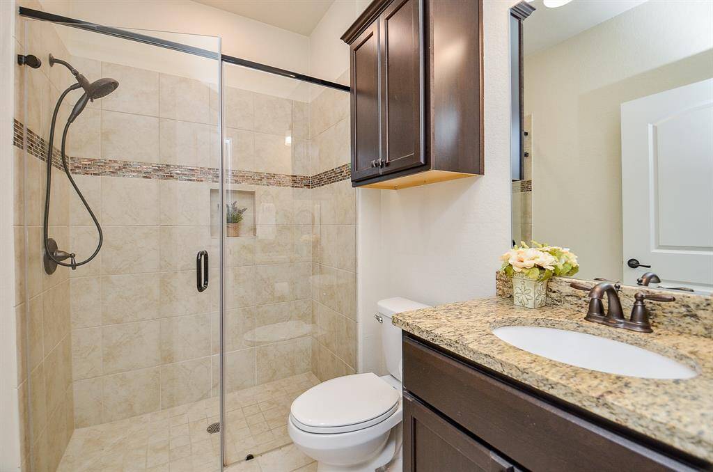 The spacious walk-in shower with frameless glass doors provides a relaxing spot to refresh and unwind.