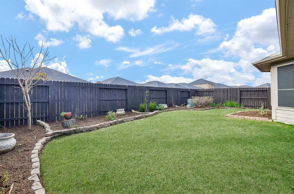 The yard is beautifully bordered by manicured landscaping, adding to the tranquil atmosphere.