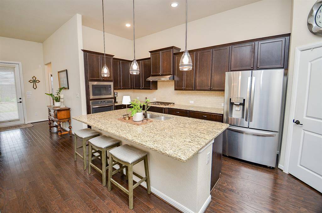 The spacious kitchen is a true centerpiece of this home, thoughtfully designed to blend functionality with style. The stunning granite countertops bring both beauty and durability to the space, perfectly paired with a stone tile backsplash that adds a touch of texture and sophistication.
