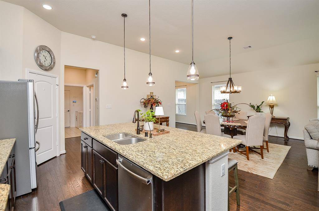 The spacious kitchen is a true centerpiece of this home, thoughtfully designed to blend functionality with style. A large island takes center stage, providing plenty of space for meal preparation and casual dining, enhanced by the warm glow of elegant pendant lighting overhead.