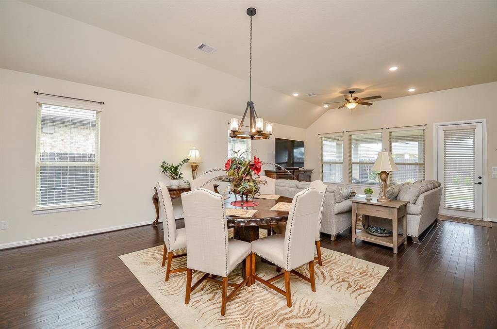 Large windows fill the space with natural light, while an elegant chandelier overhead adds a touch of sophistication with its soft, warm glow.