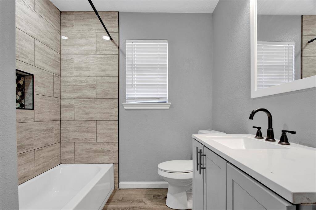The bathroom is recently updated with beautiful tile and tons of storage!