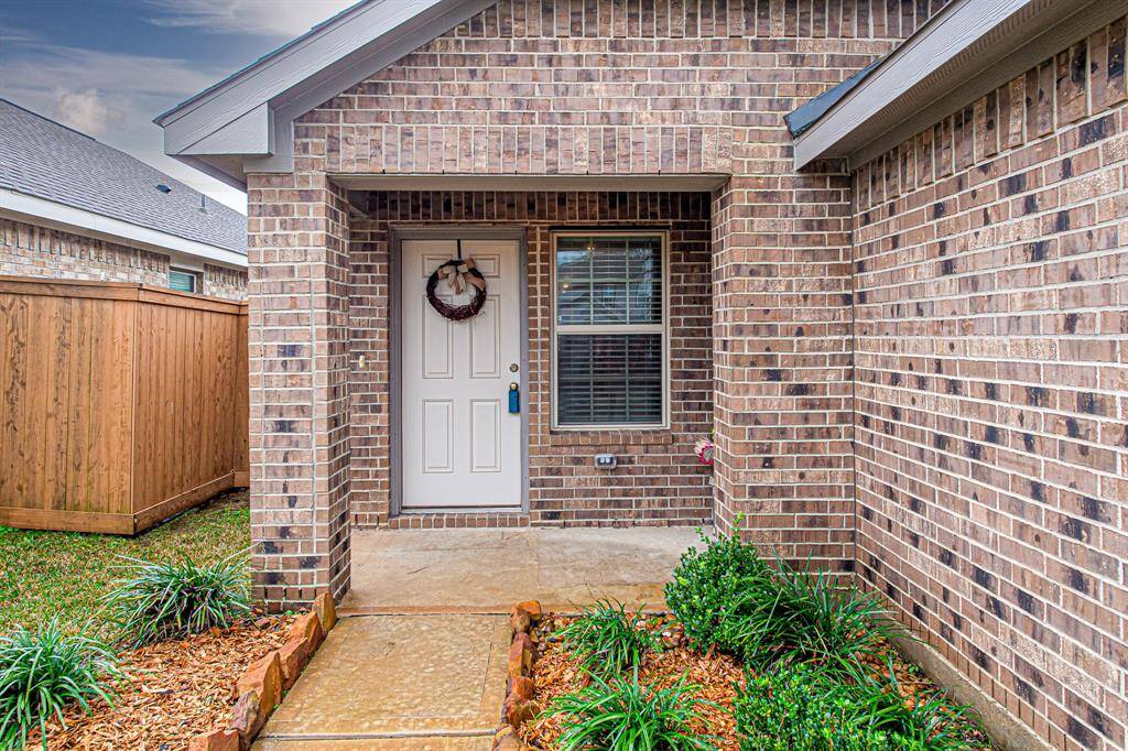 A welcoming entryway with a brick exterior featuring a covered front porch.