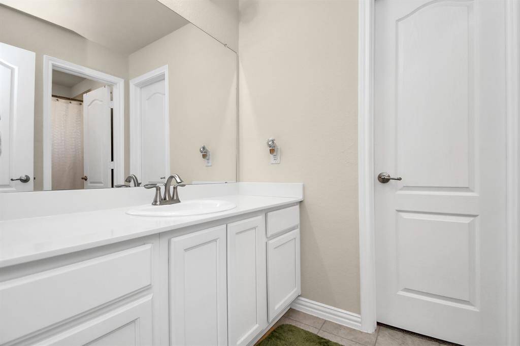 Hollywood-style full bathroom connecting two of the secondary bedrooms.