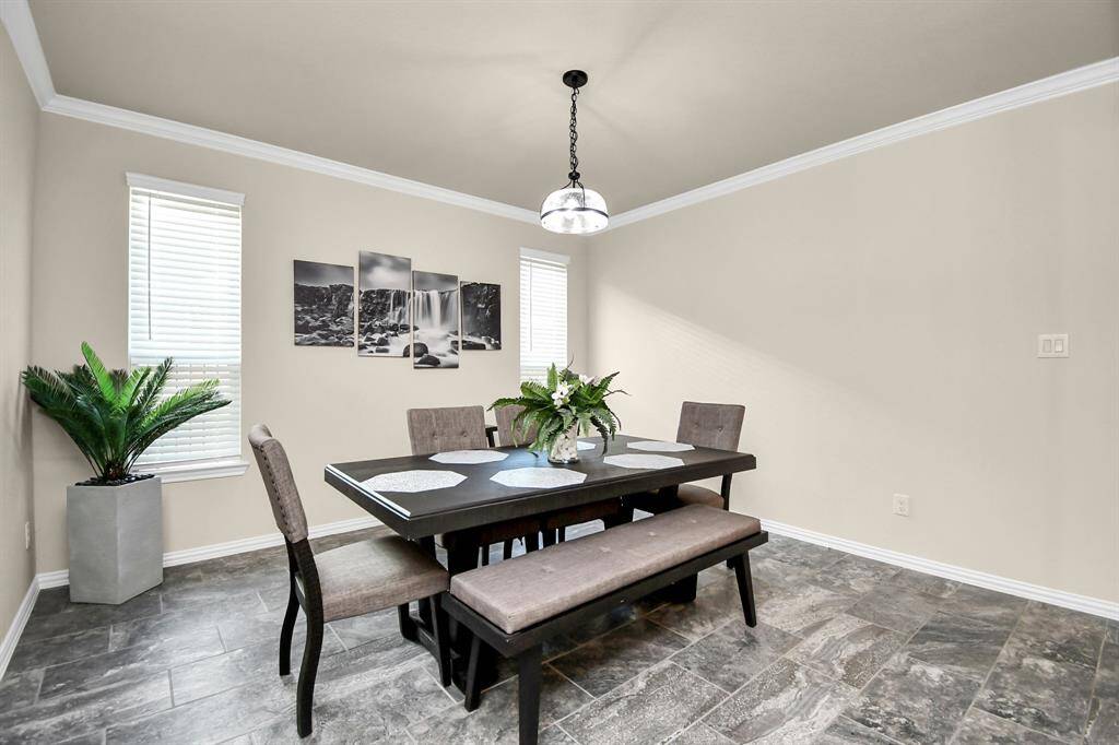 As you proceed down the hallway and go further in the home, you will come to the formal dining area. This spacious area gives you plenty of room for the largest of dining tables and any display or storage cabinets and buffets you may want to add. The beautiful upgraded tile continues from the entryway and helps add to the seemless open feeling of the home.