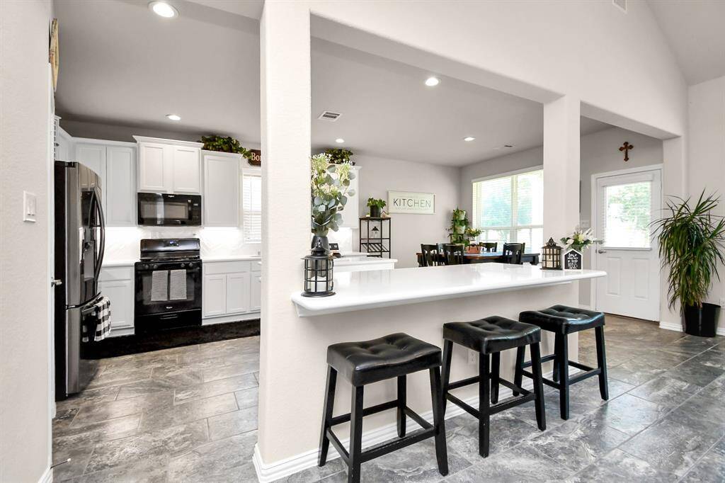 This home's open floor and beautiful kitchen really make this home shine with all of its amazing features. You have the beautiful white upgraded cabinets that give you plenty of storage. It has an island as well as a breakfast bar with plenty of room that is perfect to use as a buffet and an easy space and it all features a beautiful Quartz countertop.