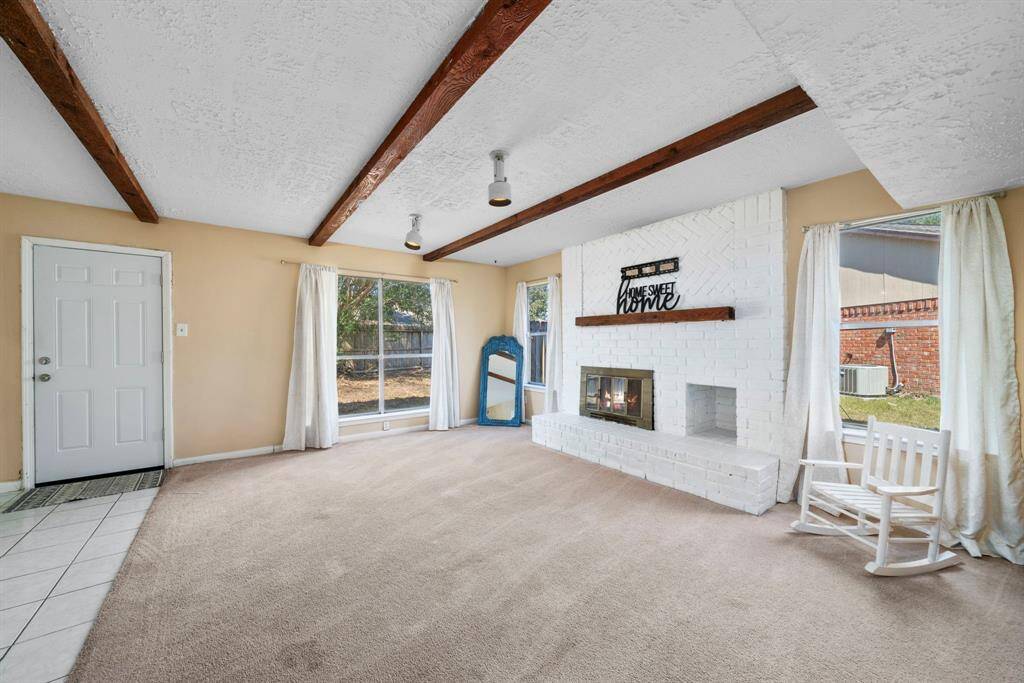 den or dining room? you decide with these exposed beams and cozy brick fireplace the sky is the limit for this large room off the kitchen