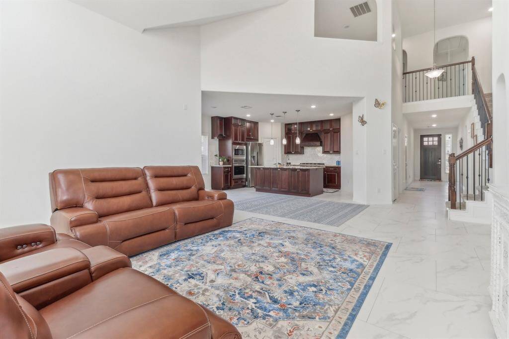 This kitchen features rich wooden cabinetry, granite countertops, and stainless steel appliances.