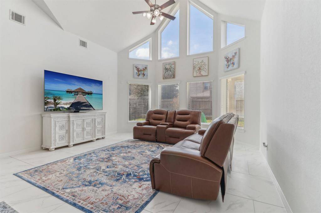 It includes a modern gas cooktop, a built-in microwave, and pendant lighting and a stylish backsplash