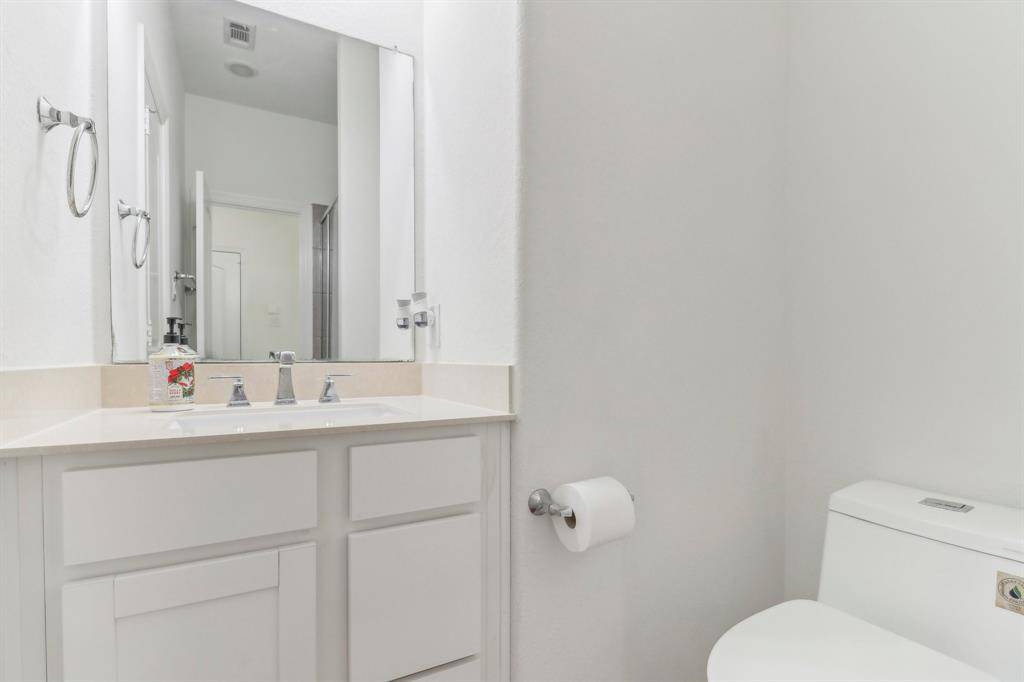 This bathroom features with a large vanity mirror, dual sinks, and sleek fixtures.