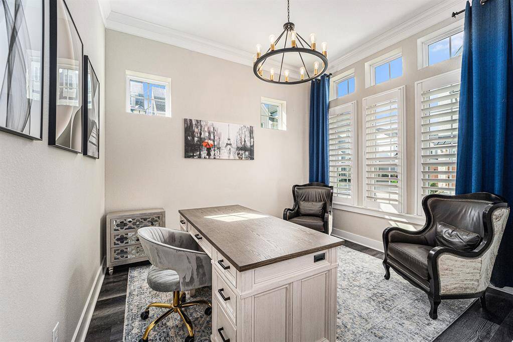 Versatile study/office space featuring a beautiful upgraded light fixture, adding a touch of elegance and creating the perfect environment for work or relaxation.