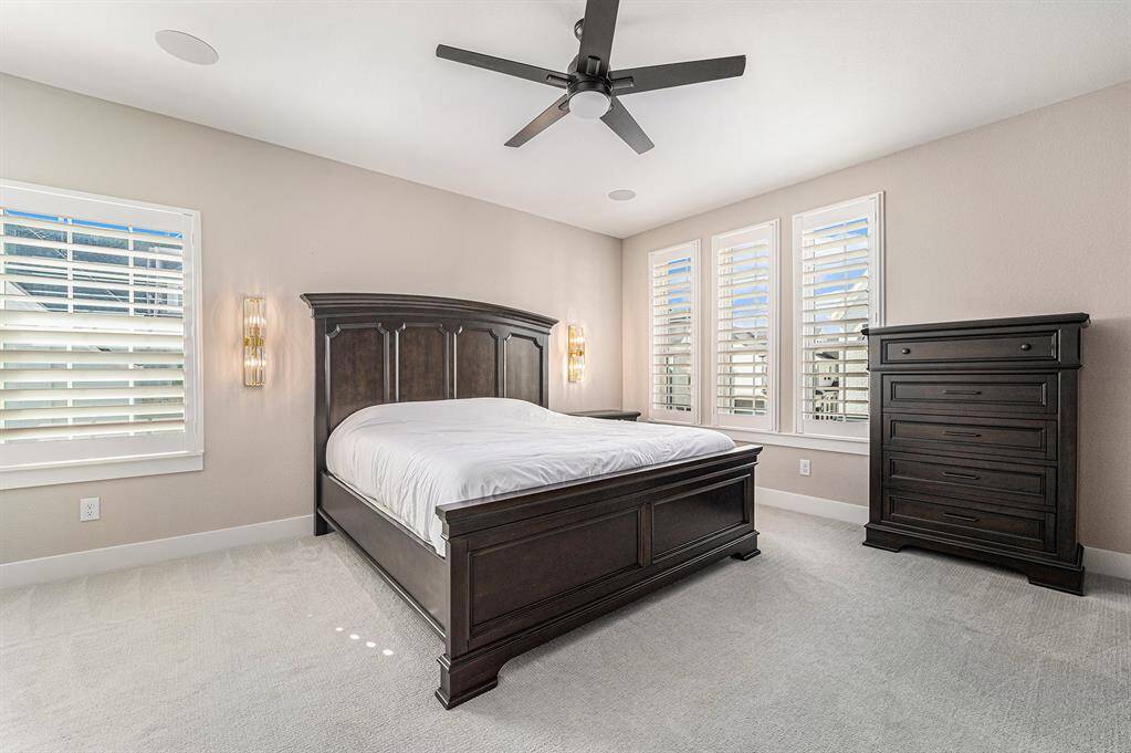 Upstairs guest suite featuring elegant shutters, beautiful sconces, and a built-in speaker system, creating a welcoming and comfortable space for guests.