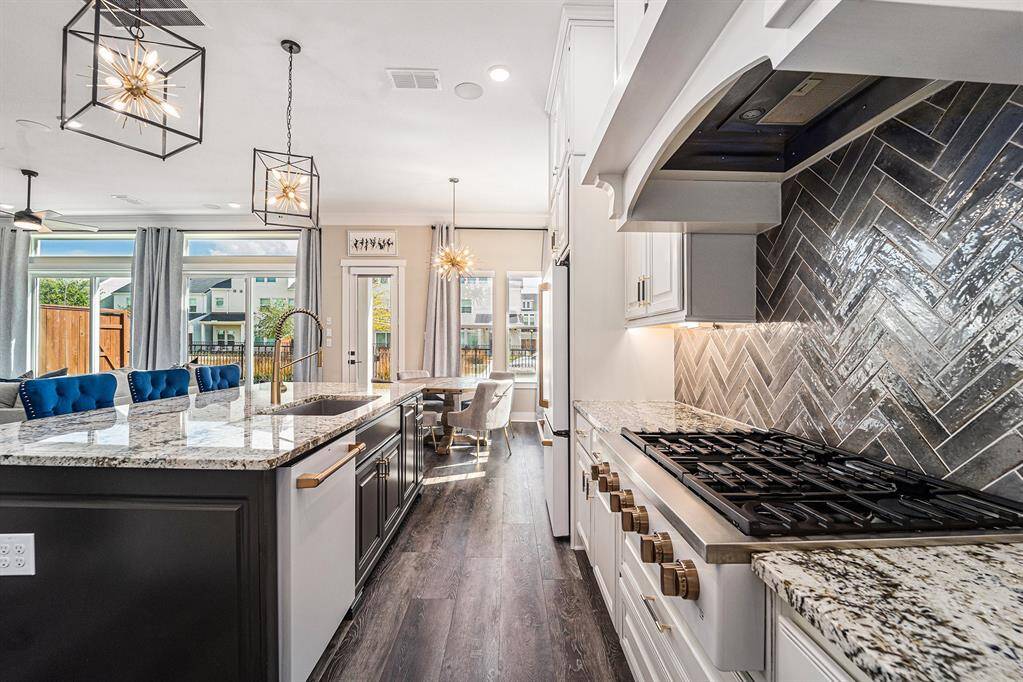 A dream kitchen featuring high-end Café appliances, stunning Romano granite countertops, and custom Kent Moore cabinetry, combining luxury and functionality in every detail.