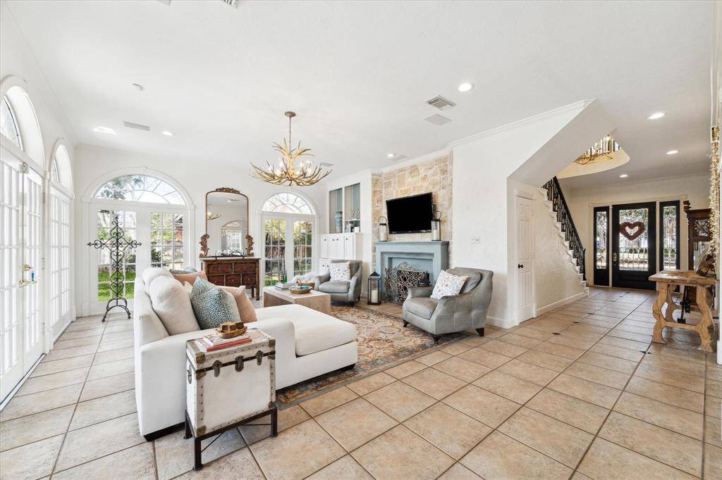 Two walls of french door windows in the family room lead to patio. Custom fireplace mantle with gas log fireplace. The fireplace can also be used as a wood burning fireplace. The antler light fixture has been replaced.