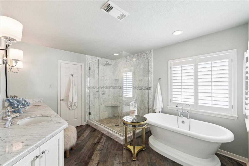 Primary bath looks brand new. High quality faucets and fixtures. Plantation shutters. Wood flooring. Separate shower and tub.
