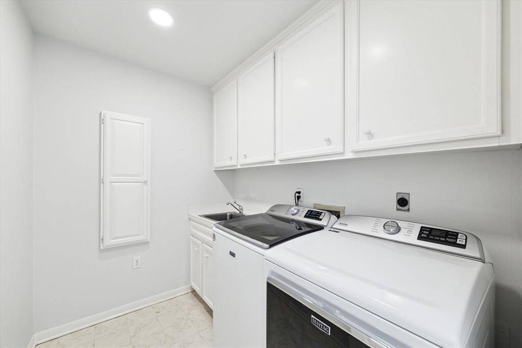 Laundry room with a fold away ironing board. Built-in cabinets. It is conveniently located upstairs by the bedroon.
