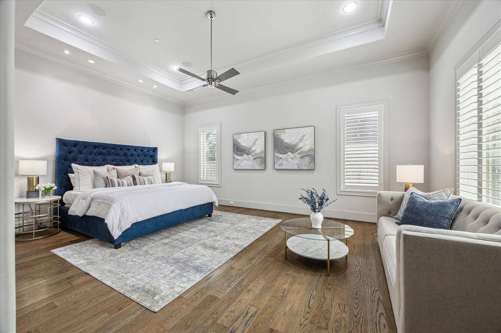PRIMARY BEDROOM:Indulge in first-floor luxury with this spacious primary suite, where expansive windows frame serene backyard views, filling the room with natural light.Designed for both comfort and luxury, this exquisite bedroom boasts soaring ceilings, an abundance of natural light, and a seamless connection to nature.