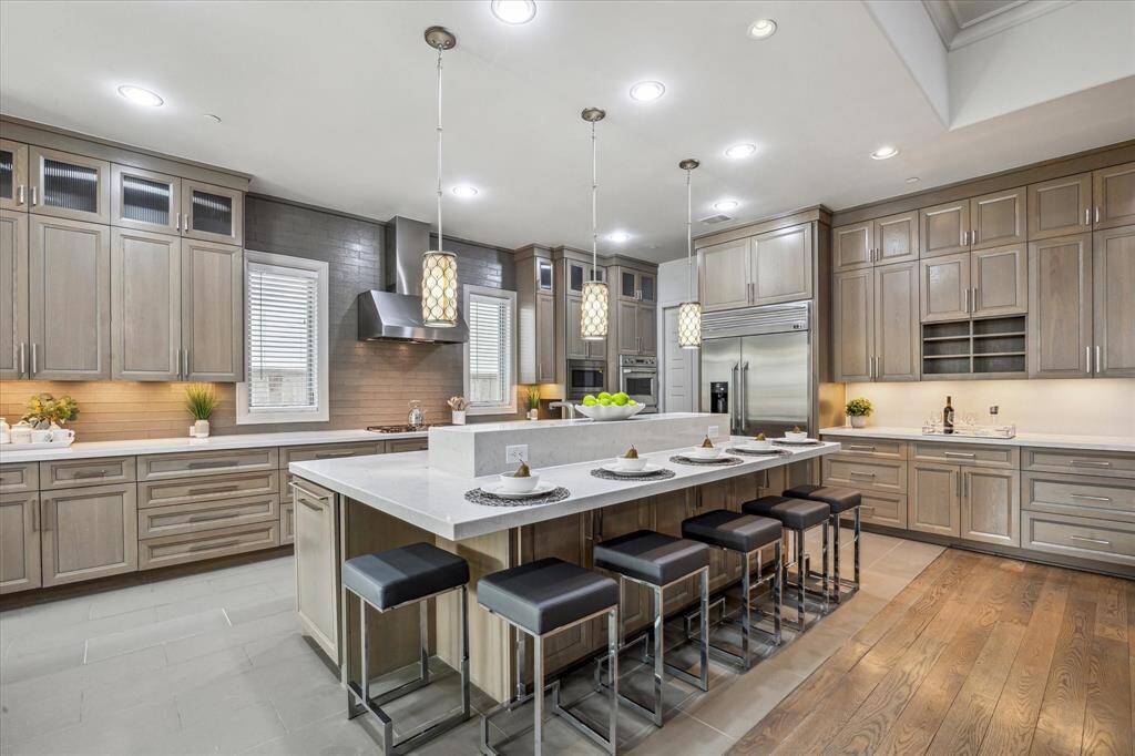 KITCHEN: The chef's kitchen is a culinary dream come true, boasting custom stained cabinetry that adds warmth and sophistication to the space. With ample counter space and a center island featuring a convenient buffet bar, this kitchen is perfect for both cooking and entertaining. Built-in storage solutions ensure everything has its place, while stainless steel appliances elevate the kitchen’s functionality and style.