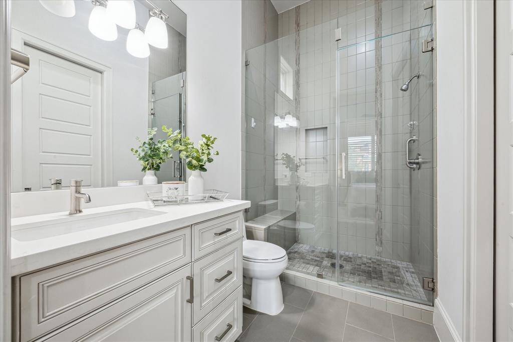 GUEST BATHROOM: This stylish first-floor en-suite guest bathroom offers both luxury and convenience. Featuring a spacious walk-in shower, elegant tilework, and designer fixtures, it provides a private retreat for guests.