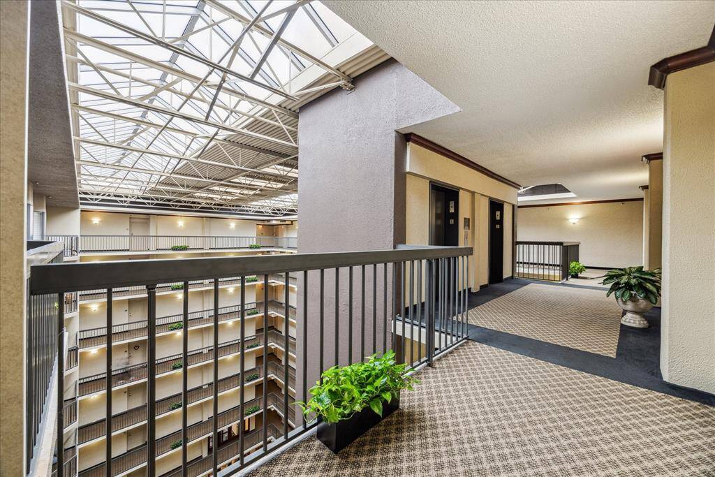 ELEVATOR LOBBY: Penthouse Level overlooking attrium filled with Alexander palm trees and tropical landscaping.