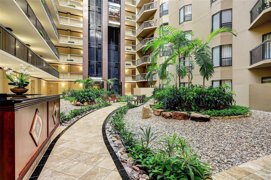 ATRIUM: Filled with Alexander palms & tropical landscaping.