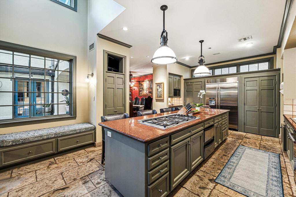 Amazing kitchen with window seat, large island with cooktop, pendant lighting.