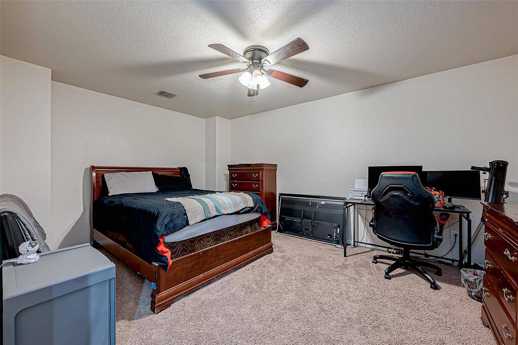 This versatile room offers various possibilities, whether as a bedroom, media lounge, or hobby space. The soft neutral palette enhances its versatility, while the ceiling fan ensures year-round comfort.