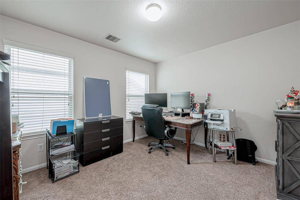 A bright and spacious office, ideal for remote work or a quiet study space. The neutral walls and soft carpeting create a focused environment, while the ample window lighting enhances the room’s airy feel.