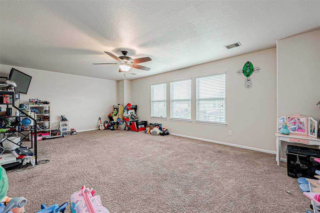 An expansive upper-level space perfect for entertainment, recreation, or a secondary lounge. With its generous size and adaptable layout, this game room can accommodate everything from a play area to a home theater setup. The ceiling fan ensures comfort, while the open floor space allows for various possibilities.