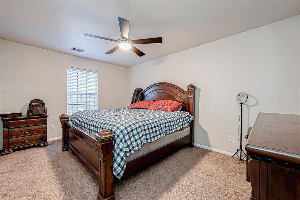 Bright and airy, this bedroom offers a generous layout with a large window and neutral tones. The ceiling fan provides both style and comfort.