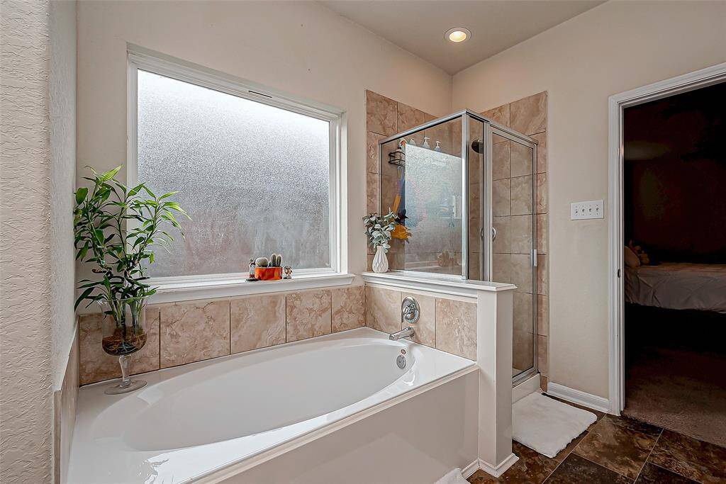 The separate soaking tub, placed beneath a frosted window, adds a touch of luxury.