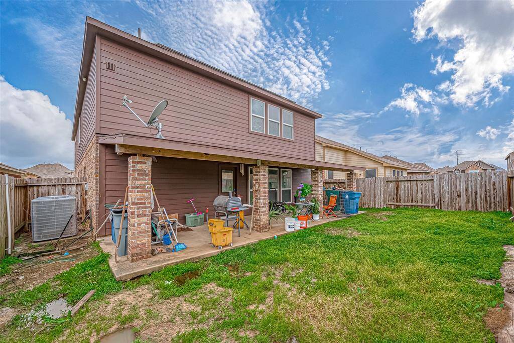 With its expansive footprint, this covered patio is perfect for outdoor gatherings or quiet evenings. The sturdy brick pillars add character, while the open backyard offers a lush green backdrop.